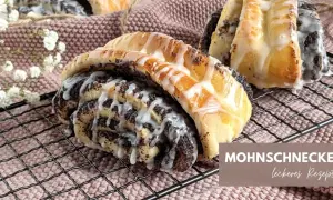 Mohnschnecken mit Zuckerguss auf einem Gitter. Ein leckeres Rezept für süße Mohnschnecken.
