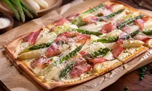Ein köstlicher Spargel Flammkuchen mit zartem Speck und frischem Spargel, bestreut mit Parmesan.