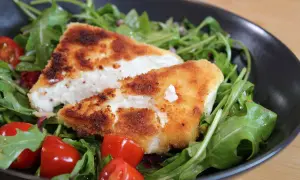Knusprig panierter Feta auf Rucolasalat mit Kirschtomaten. Ein leichtes Hauptgericht mit Feta, das schnell zubereitet ist.