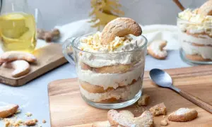 Schichtdessert im Glas mit Keksen und Sahne, garniert mit Schokostreuseln. Ein festliches Dessert, das zum Genießen einlädt.