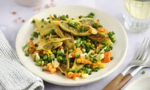 Gebratene Maultaschen mit Erbsen, Karotten und Mais, garniert mit Schnittlauch. Ein herzhaftes Gericht, das Lust auf mehr macht.
