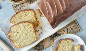 Saftiger Nusskuchen mit Schokoladenglasur, perfekt für Ihr nächstes nusskuchen rezept. Daneben liegen Walnüsse und ein Stück Kuchen.
