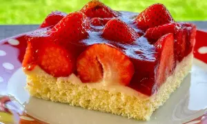 Ein Stück saftiger, **schneller Erdbeerkuchen vom Blech ohne Pudding**, belegt mit frischen Erdbeeren und glänzendem Tortenguss.