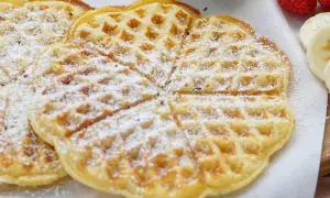 Zarte Buttermilch Waffeln, bestäubt mit Puderzucker, warten auf ein leckeres Frühstück.