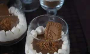 Cremiges Lotus Dessert im Glas, garniert mit Keksstückchen und einem ganzen Keks.