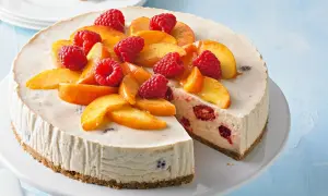 Cremiger Pfirsich Melba Kuchen mit frischen Himbeeren und Pfirsichspalten, ein Genuss für Augen und Gaumen.