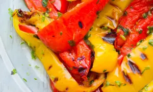 Leckeres Paprika grillen mit Kräutern. Rote und gelbe Paprikastreifen sind saftig und leicht angekohlt.