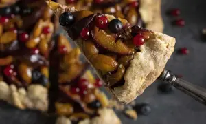 Ein Stück fruchtige Galette mit Pflaumen und Beeren, perfekt für ein einfaches Galette Rezept.