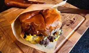 Saftiger Cheeseburger Rolle auf Holzbrett, bereit zum Genuss.