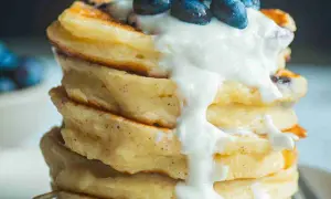 Ein Stapel fluffiger Protein Pancakes mit Blaubeeren und Joghurt. Perfekt für ein gesundes Frühstück, inspiriert von einem protein pancakes rezept.