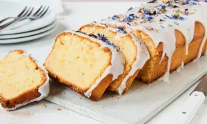 Saftiger Kuchen mit Mascarpone, verziert mit blauen Blüten und Zuckerguss.