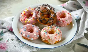 Sechs bunte Donuts mit Streuseln und Sternen auf einem Teller, ein köstliches Donuts Rezept für jeden Anlass.