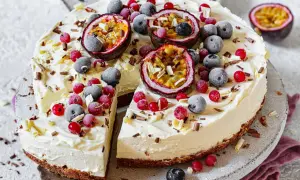 Ein erfrischender Sommerkuchen mit cremiger Füllung, garniert mit Passionsfrucht, Blaubeeren und roten Johannisbeeren.