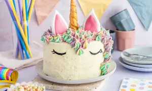Ein magischer einhorn kuchen mit bunten Tupfen und einem goldenen Horn. Perfekt für eine märchenhafte Feier.