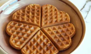 Herzförmige Waffeln ohne Zucker, goldbraun gebacken, liegen auf einem Teller.