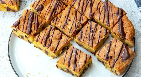 Saftige Blondies mit Schokostückchen, verziert mit Schokoladenglasur. Ein köstliches Rezept für Blondies, das jeden begeistert.