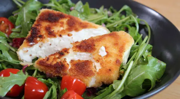 Knusprig panierter Feta auf Rucolasalat mit Kirschtomaten. Ein leichtes Hauptgericht mit Feta, das schnell zubereitet ist.