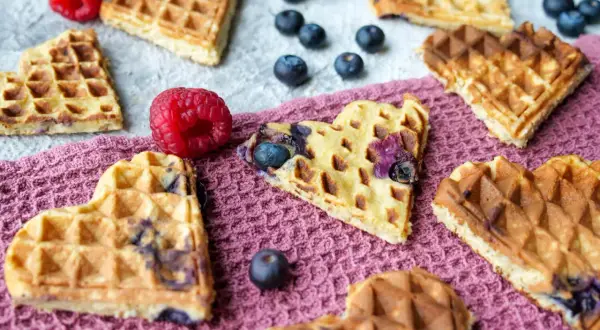 Herzförmige Baby Waffeln mit Blaubeeren und Himbeeren, ein süßer Genuss für jeden Anlass.