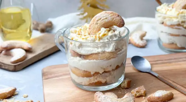 Schichtdessert im Glas mit Keksen und Sahne, garniert mit Schokostreuseln. Ein festliches Dessert, das zum Genießen einlädt.