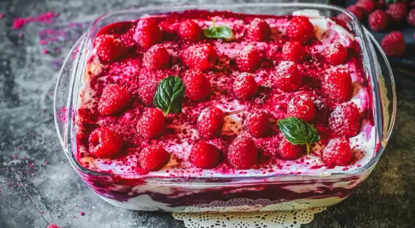 Himbeer Tiramisu in einer Glasschale, garniert mit frischen Himbeeren und Minze. Ein köstlicher Nachtisch.