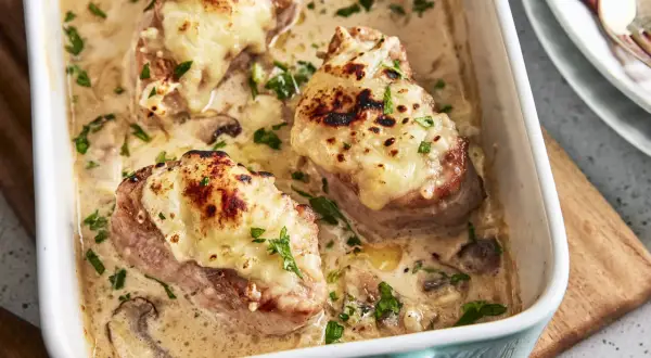Saftige Medaillons in cremiger Pilzsoße, überbacken mit Käse. Ein köstliches Rezept für den Backofen, garniert mit Petersilie.