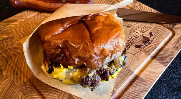 Saftiger Cheeseburger Rolle auf Holzbrett, bereit zum Genuss.