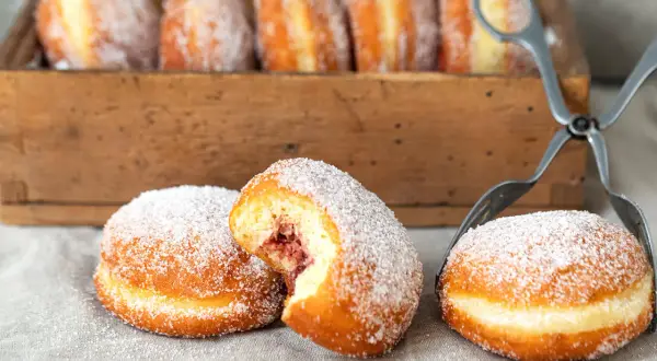 Frisch gebackene Berliner mit Marmeladenfüllung, bestreut mit Zucker. Ein köstliches berliner rezept für den Genuss.