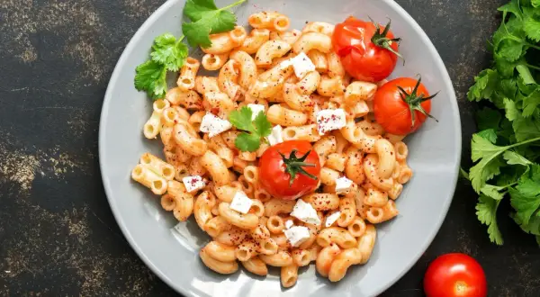 Feta Pasta aus dem Ofen: cremige Makkaroni mit geschmolzenem Feta, Kirschtomaten und frischer Petersilie.