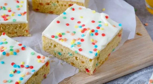 Bunte Streusel zieren das weiße Zuckerguss-Topping dieses leckeren Papageienkuchen Rezepts. Perfekt für jede Feier!