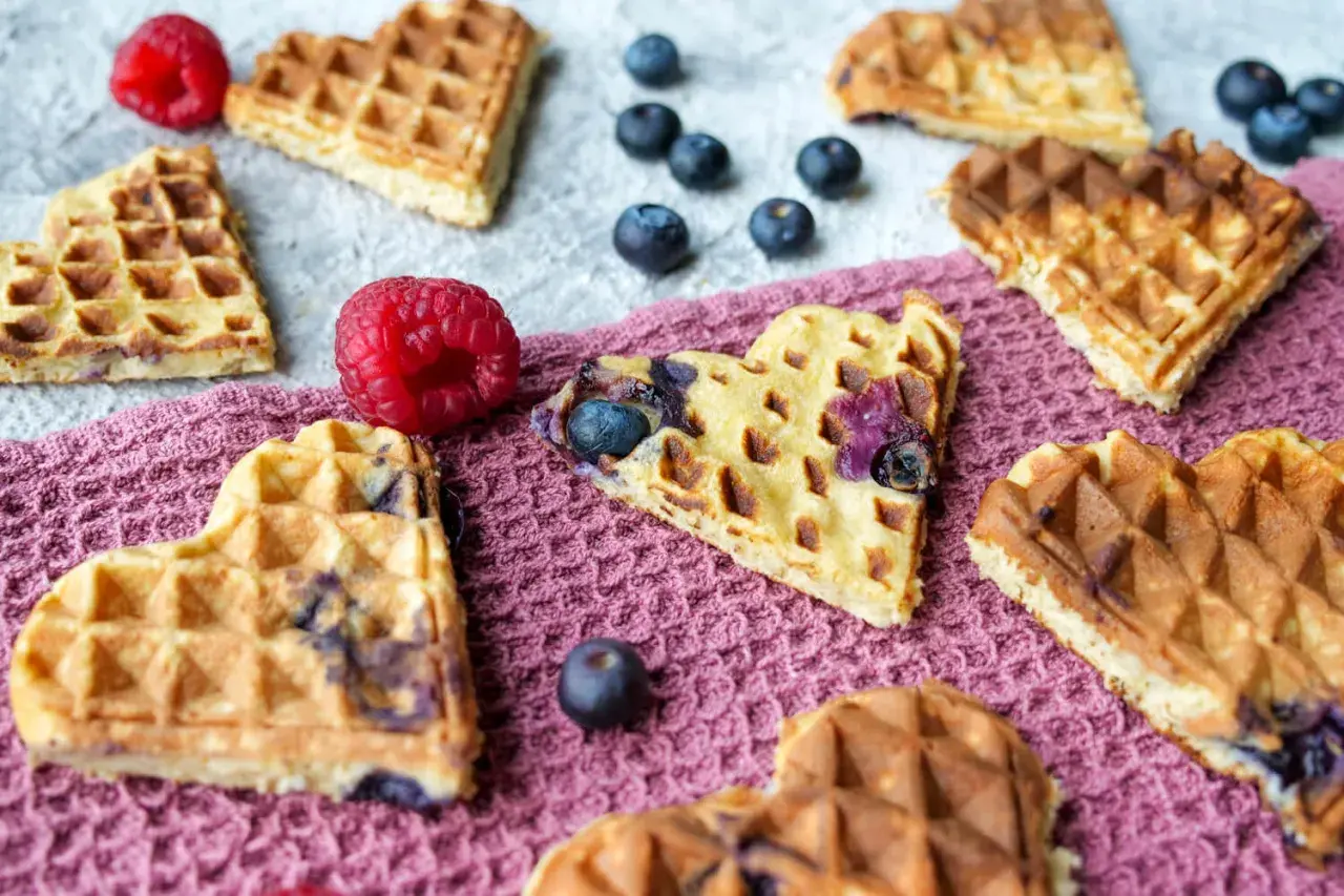 Herzförmige Baby Waffeln mit Blaubeeren und Himbeeren, ein süßer Genuss für jeden Anlass.