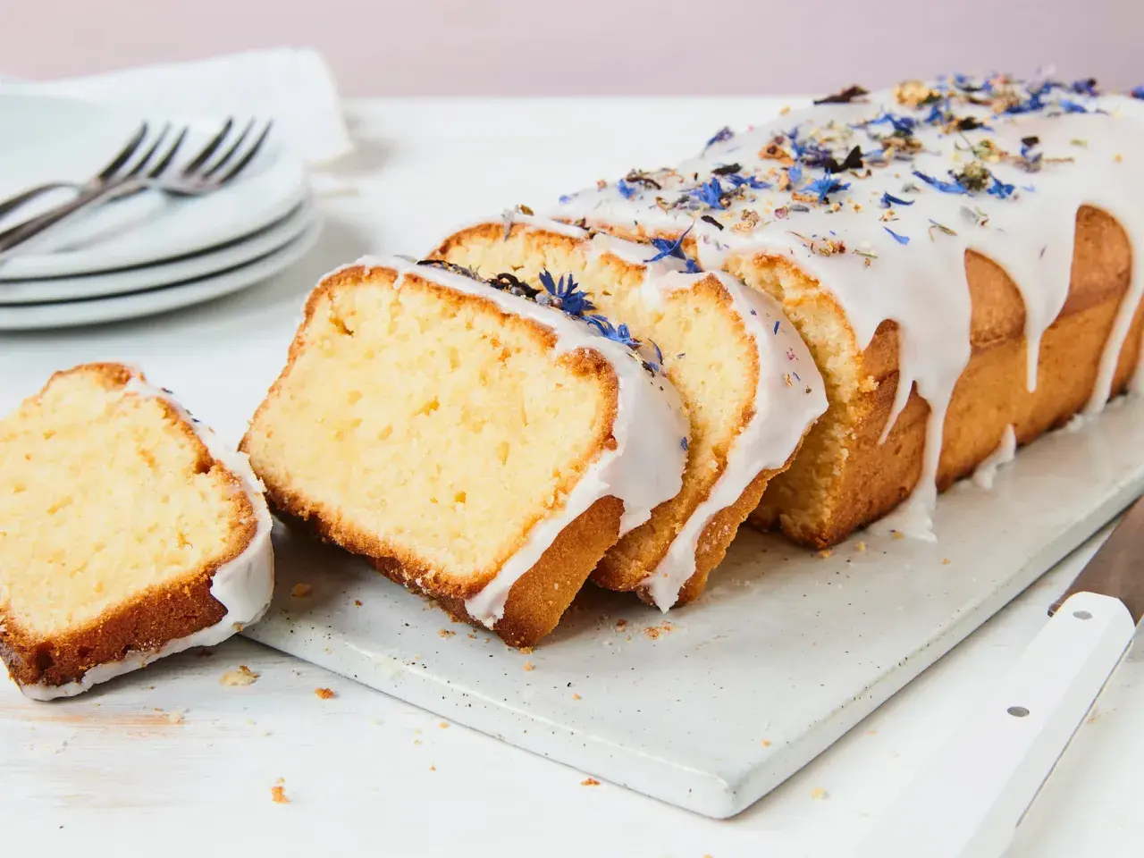 Saftiger Kuchen mit Mascarpone, verziert mit blauen Blüten und Zuckerguss.
