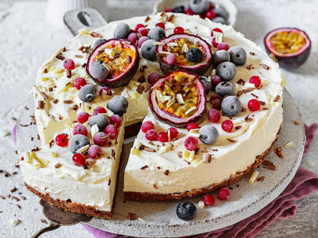 Ein erfrischender Sommerkuchen mit cremiger Füllung, garniert mit Passionsfrucht, Blaubeeren und roten Johannisbeeren.