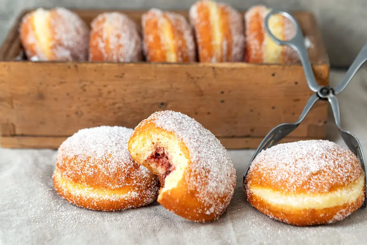 Frisch gebackene Berliner mit Marmeladenfüllung, bestreut mit Zucker. Ein köstliches berliner rezept für den Genuss.
