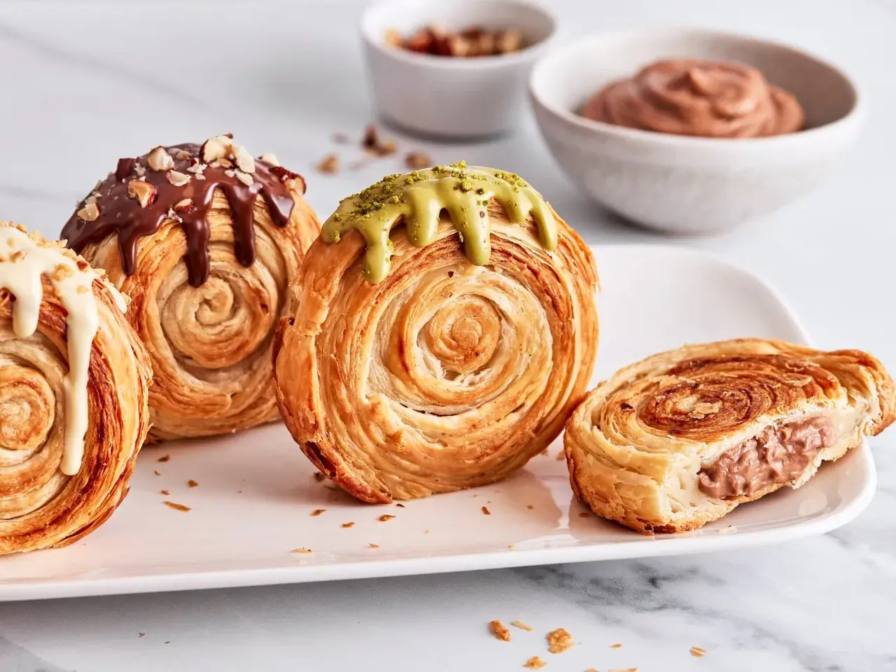 Saftige New York Rolls mit Schokolade, Pistazie und weißer Glasur, eine köstliche Versuchung.