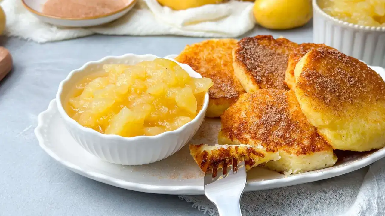 Goldbraune Quarkkeulchen, bestreut mit Zimt und Zucker, serviert mit Apfelmus. Ein leckeres Quarkkeulchen Rezept f&uuml;r Genie&szlig;er.