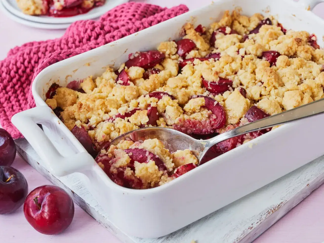 Ein warmer pflaumen crumble mit knuspriger Streuseldecke, bereit zum Servieren.