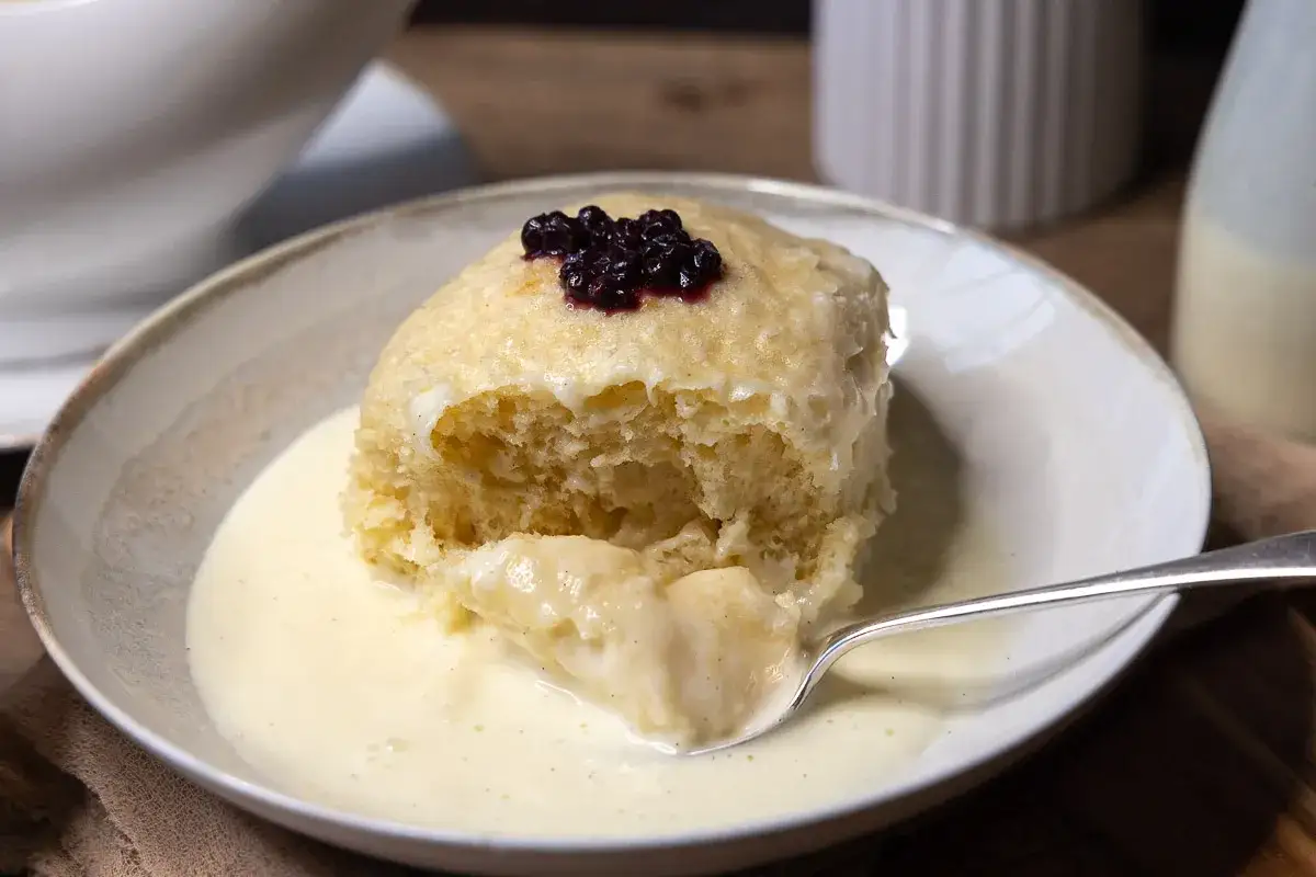Ein fluffiger Dampfnudel-Kloß mit Vanillesauce und Blaubeeren. Ein köstliches Rezept für Dampfnudeln.