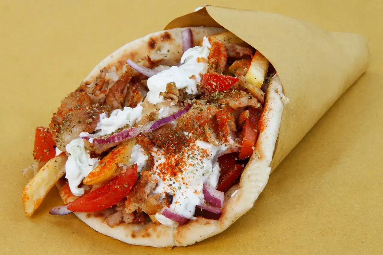 Saftiger Gyros im Pitabrot mit Tzatziki, Tomaten, Zwiebeln und Pommes. Ein leckeres Gyros rezept zum Genie&szlig;en.