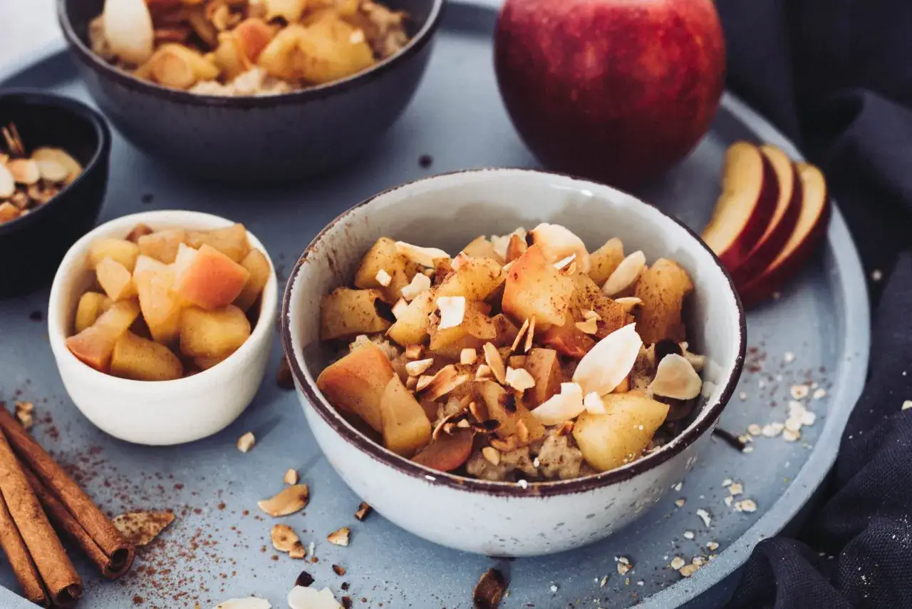 Herzhaftes Bratapfel Porridge mit Zimt und Mandelsplittern, garniert mit frischen Apfelst&uuml;cken. Ein Genuss f&uuml;r kalte Tage.