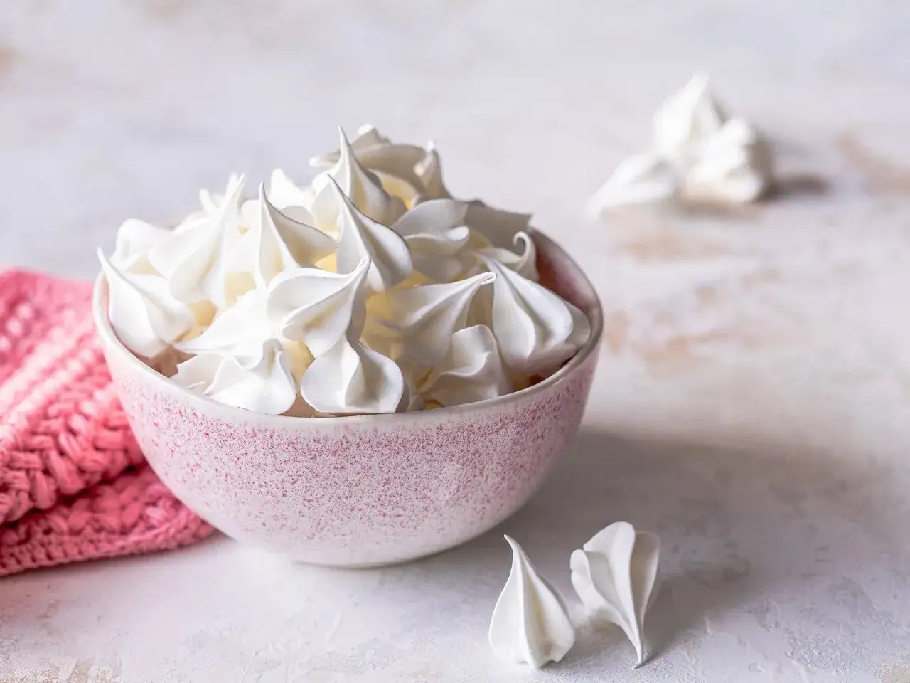 Sch&uuml;ssel voller luftiger Baisers, perfekt f&uuml;r ein einfaches Baiser Rezept. Daneben ein paar einzelne Baiser-H&auml;ppchen.