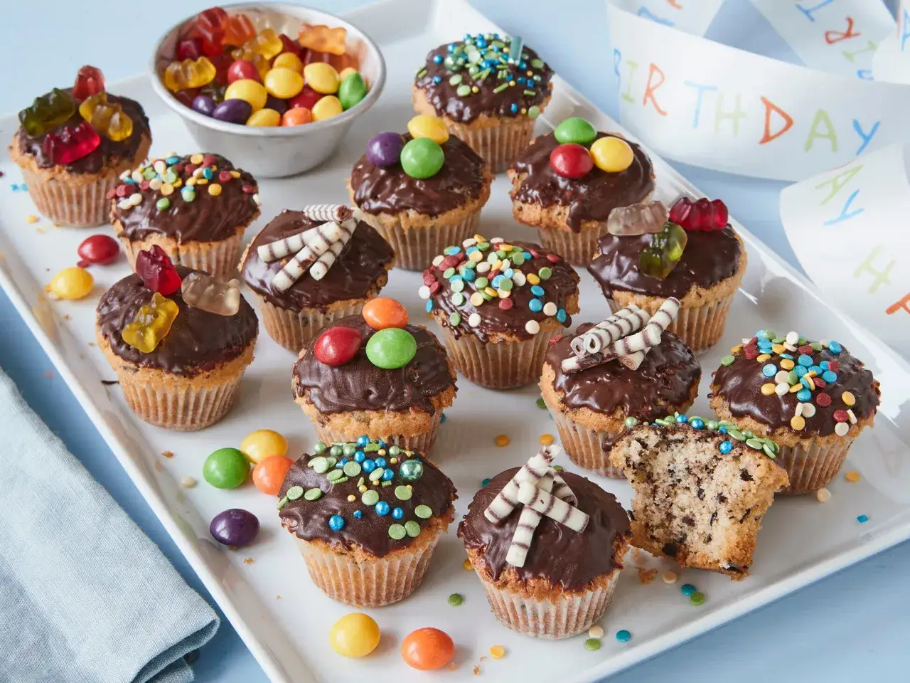 Bunte Muffins mit Schokoglasur und Gummib&auml;rchen, perfekt f&uuml;r einen Kindergeburtstag.
