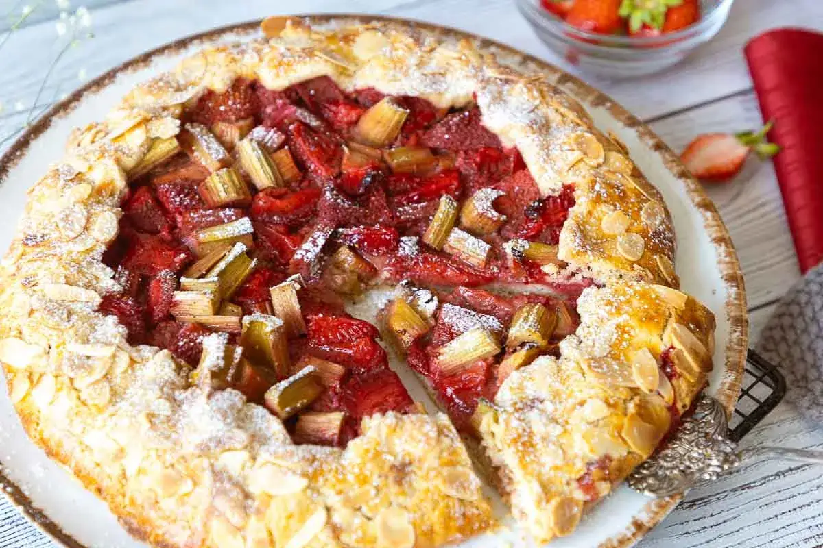 Erdbeer-Rhabarber-Galette mit Mandelsplittern, ein k&ouml;stliches galette rezept, best&auml;ubt mit Puderzucker.
