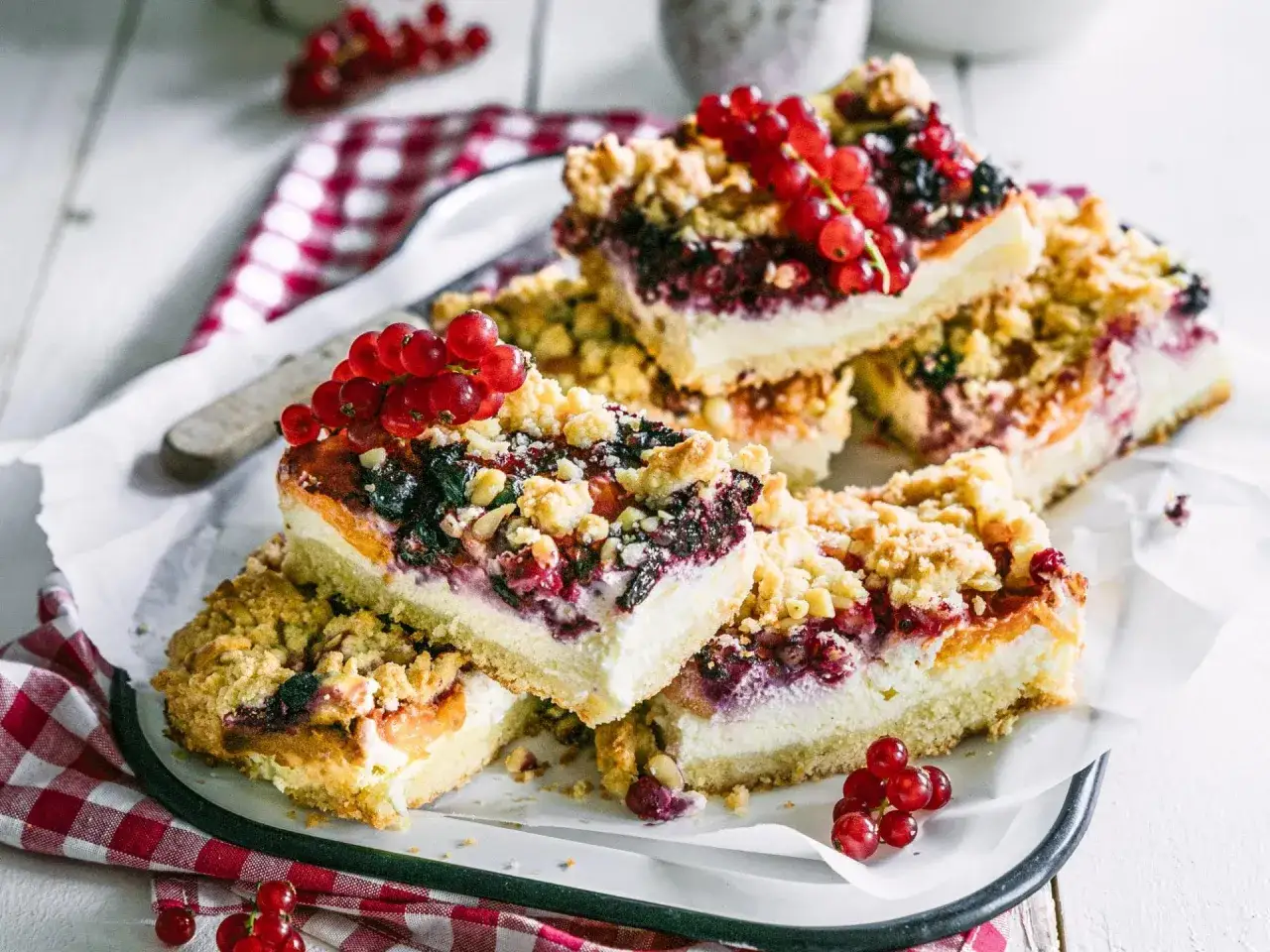 Saftige Kuchenst&uuml;cke mit Beeren und Streuseln, inspiriert von schwarzen johannisbeere rezepten. Frische rote Johannisbeeren garnieren den s&uuml;&szlig;en Genuss.