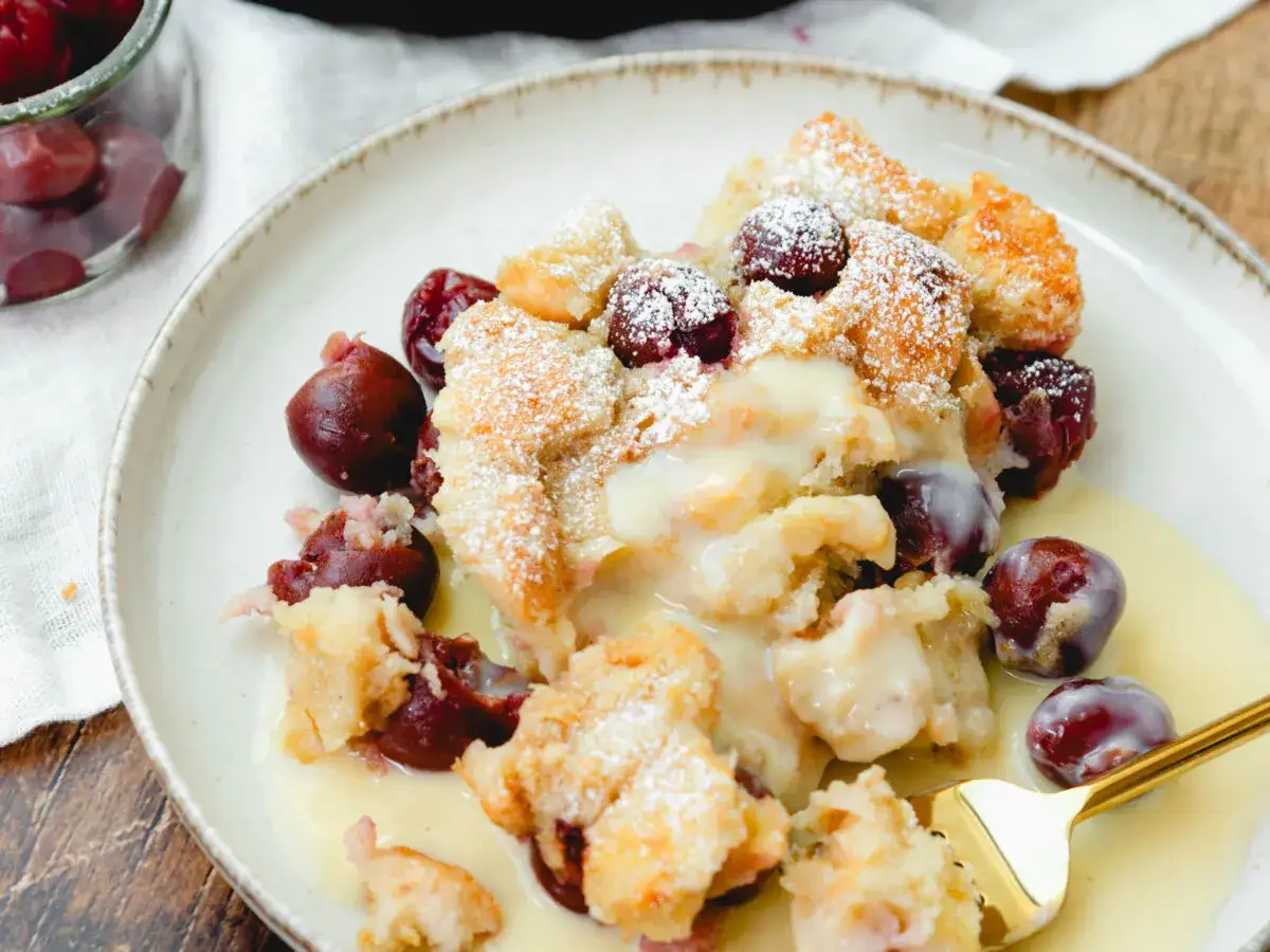 Ein köstlicher Kirschenmichel, frisch aus dem Ofen, mit Puderzucker bestäubt und in Vanillesauce serviert. Ein tolles Rezept!