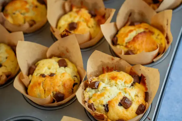 Frisch gebackene Schoko-Muffins im Papierförmchen, bereit für ein leckeres Muffins Rezept.