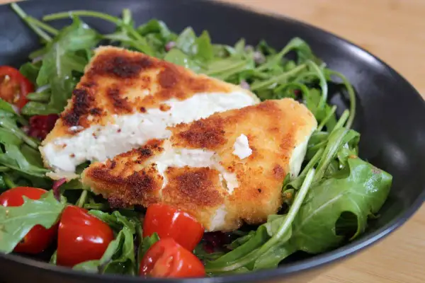 Knusprig panierter Feta auf Rucolasalat mit Kirschtomaten. Ein leichtes Hauptgericht mit Feta, das schnell zubereitet ist.