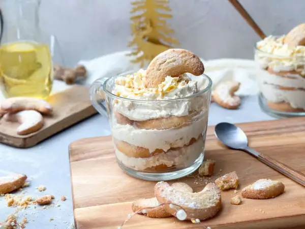 Schichtdessert im Glas mit Keksen und Sahne, garniert mit Schokostreuseln. Ein festliches Dessert, das zum Genießen einlädt.