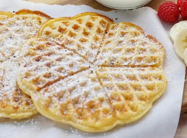 Zarte Buttermilch Waffeln, bestäubt mit Puderzucker, warten auf ein leckeres Frühstück.