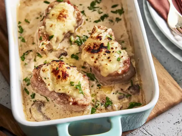 Saftige Medaillons in cremiger Pilzsoße, überbacken mit Käse. Ein köstliches Rezept für den Backofen, garniert mit Petersilie.