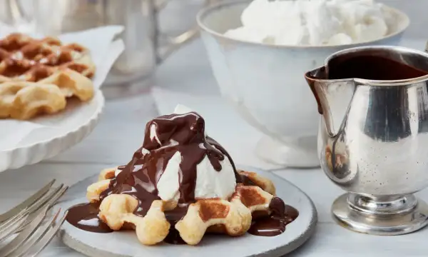Belgische waffeln mit Sahne und Schokoladensauce, ein Genuss für jeden Gaumen.